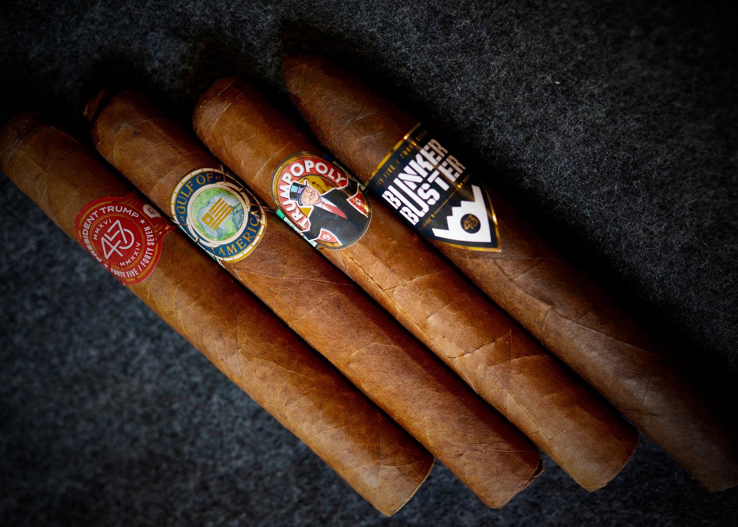 Three cigars with visible labels on a dark textured background